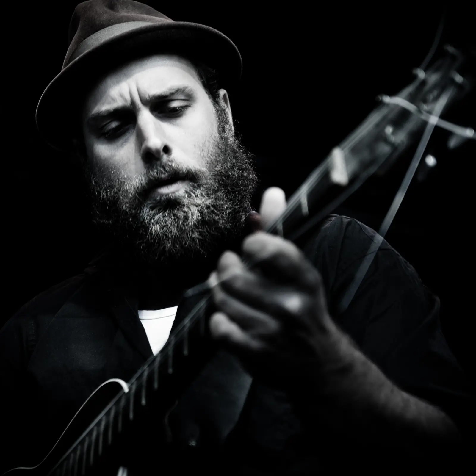 Close-up black-and-white portrait of Big Creek Slim playing guitar